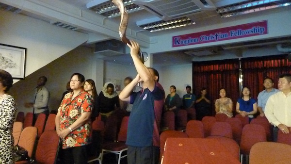 Attendees standing in worship