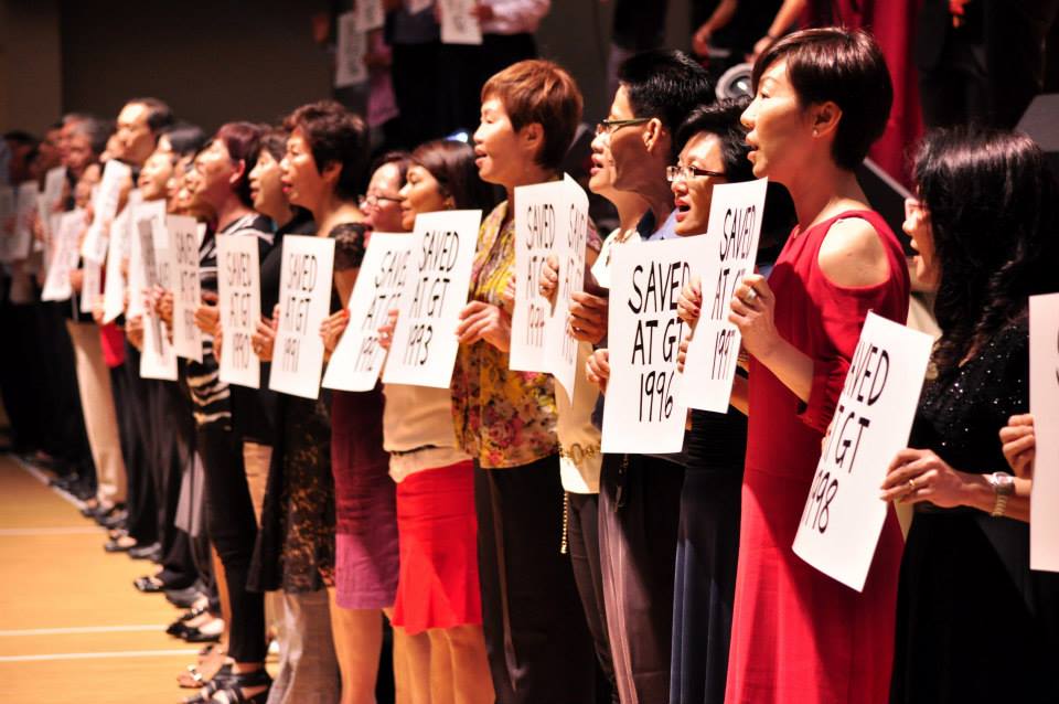 Members of GT holding placards of the year they got got saved in GT, stretching from 1963 all the way to 2013