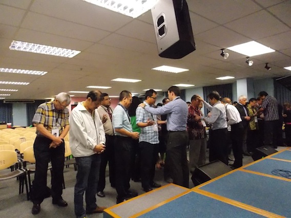 The speakers praying for the pastors