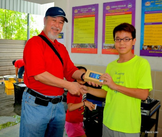 Rev David Loo presenting the prize to the winner of Samsung Phone Raffles