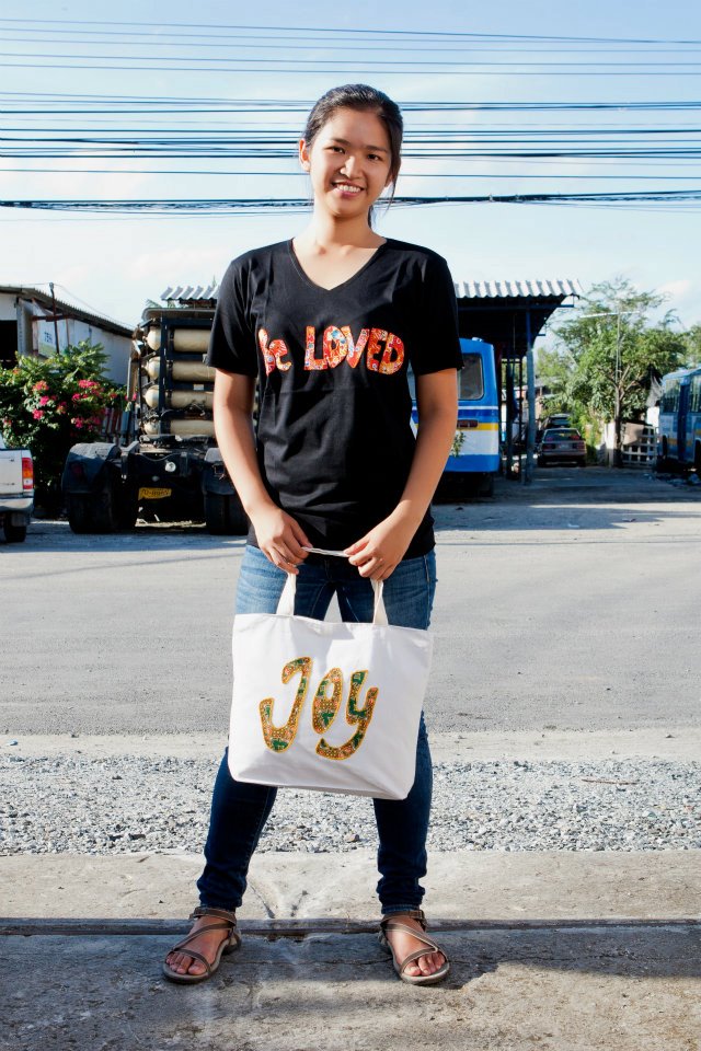 Karen showcasing the shirt and bag sewn by the elderly poor in the slum