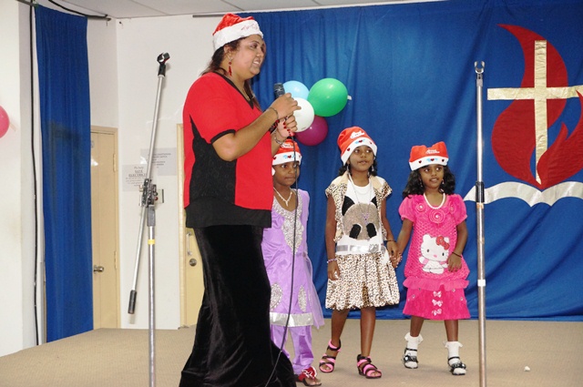 Sheila, emcee for the night with the children performing the Santa Claus dance on-stage