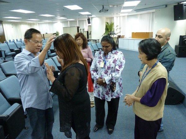 Eddy Yong praying for God to heal the people