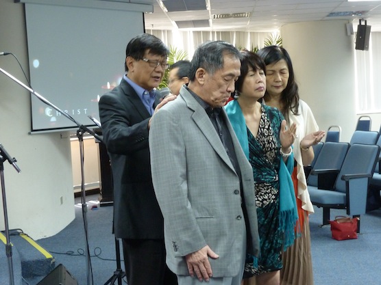 Pr Peter Sze and wife See Fen praying for Datuk Tony Tiah and wife Datin Alicia