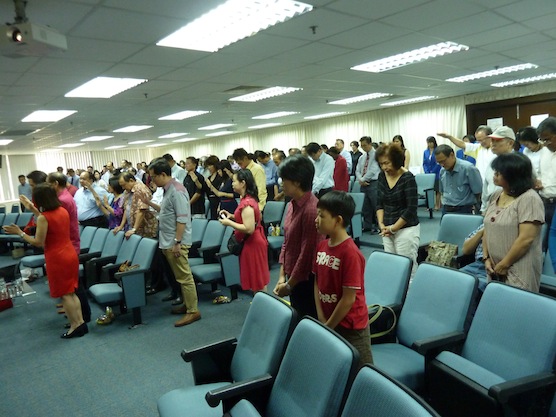 The attendees raising their hands in prayer for Datuk Tony Tiah and Datin Alicia