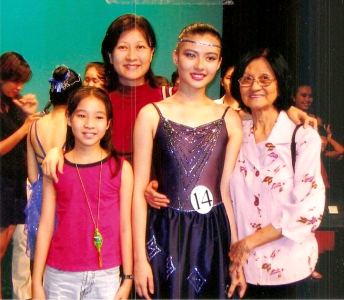 Carey Ng posing her mother, younger sister, and grandmother as a gymnast