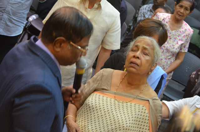 Prophet Dr Anand Sitra praying for a sister-in-Christ