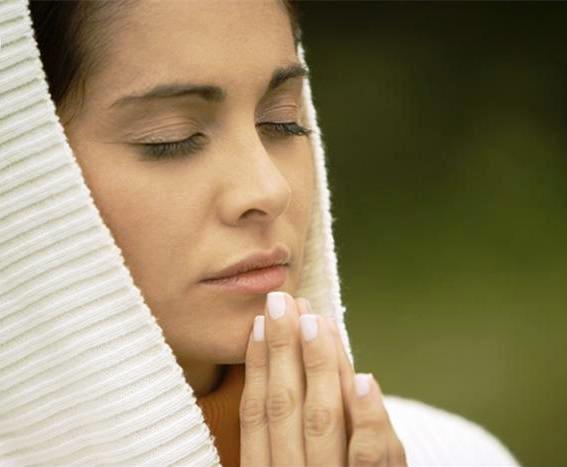 Close-up of a young woman praying with her eyes closed