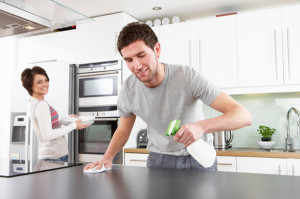 young-happy-man-helping-smiling-wife-clean-kitchen