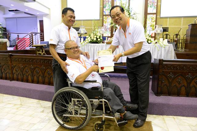 Dr David Wong, Chairman of Malaysian CARE, handing Yap Khen Siong a 20-year-award 