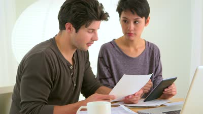 stock-footage-mixed-race-couple-looking-over-finances