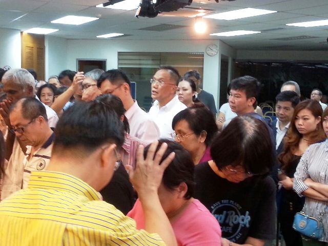 Eddy Yong praying for an attendee