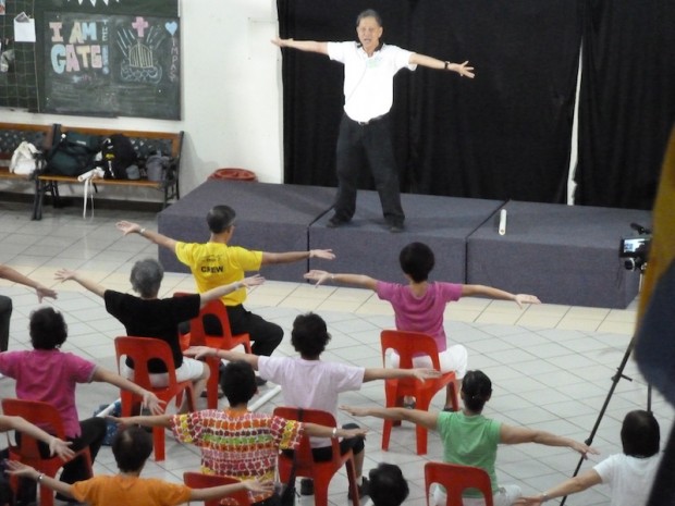 Yeoh Kit Koon doing a stretching series in the Sit Down Exercise