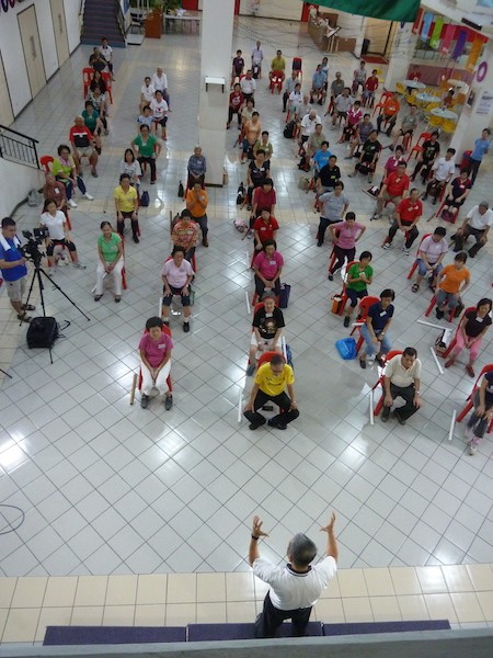 Yeoh Kit Koon explaining each step of the exercise to the older folks