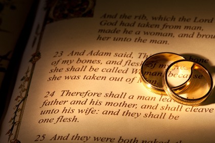 Rings and Bible with Genesis text of Adam and Eve, a typical wedding text - the book illustration is copied from a 400 years old bible.