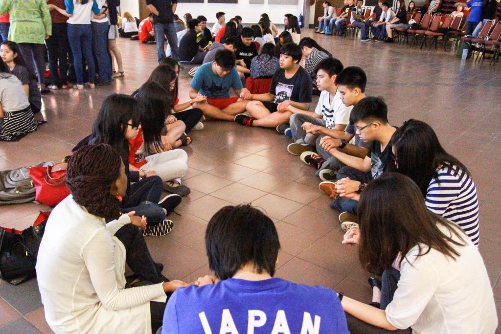 Groups of young people praying together Photo Credit: Naaman