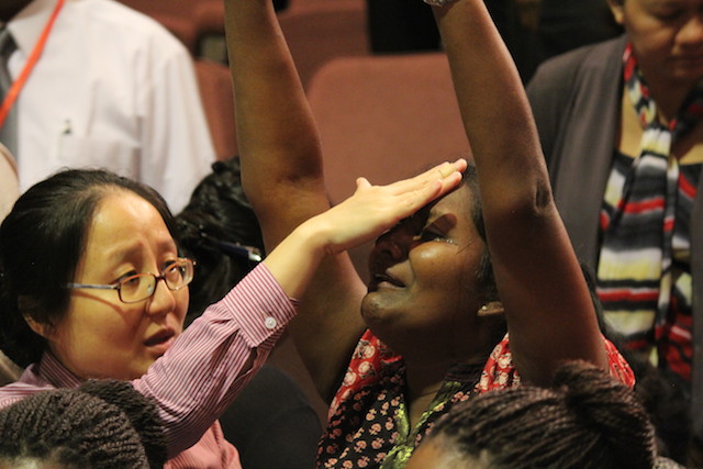 A sister-in-Christ lifting her hands for God to heal her