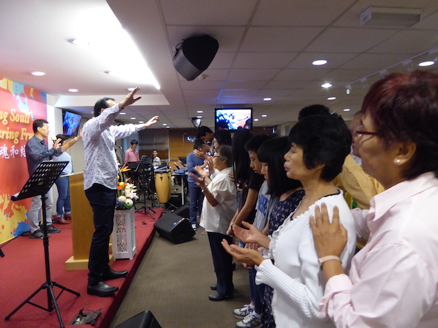 Pastor Lawrence praying for blessing and healing for the school students and elderly folks