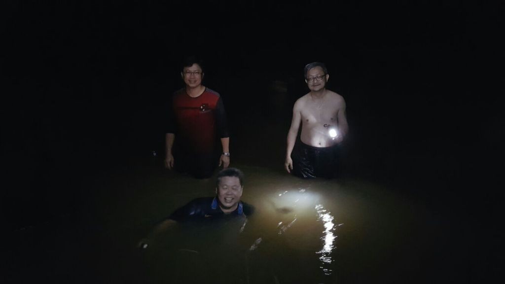 The guys having a dip in the river