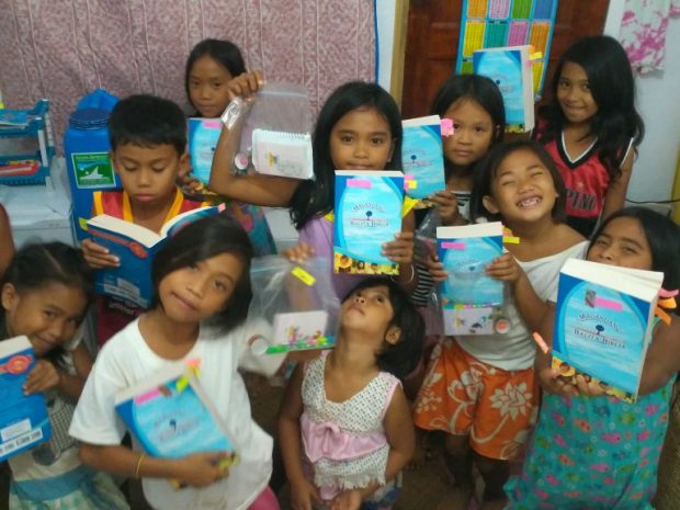 The kids ecstatic to receive brand new Bibles (in her tiny studio)