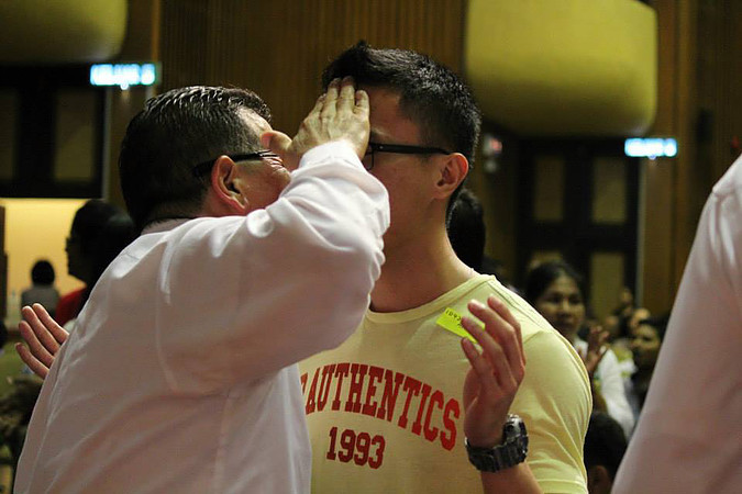 Rev Eli praying for a brother-in-Christ at the first healing rally in Malaysia last year