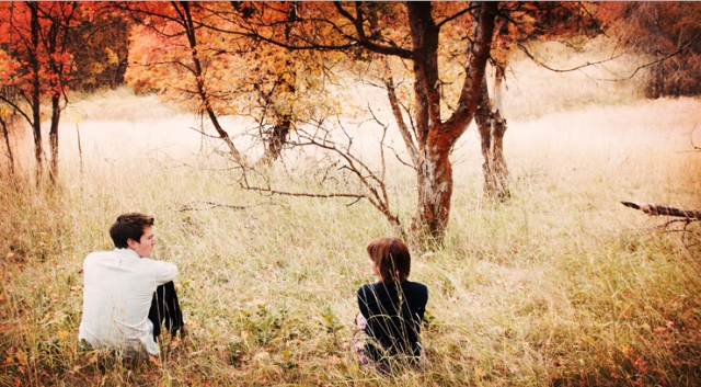 girl-and-boy-sitting-outside-away-from-each-other