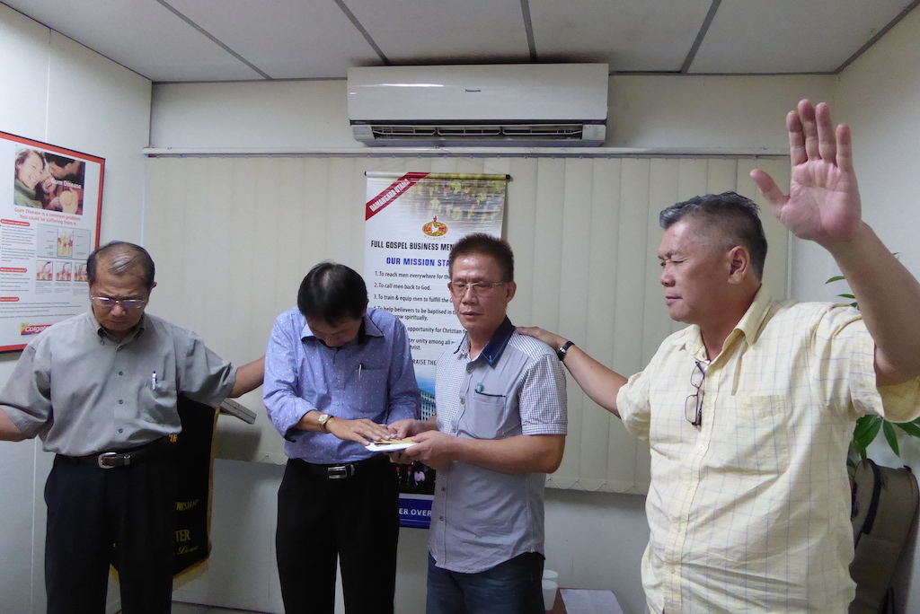 Daniel Liew (right) who was part of Malaysian Care and had reached out to Sam in prison, praying for Sam (2nd from right) after the sharing