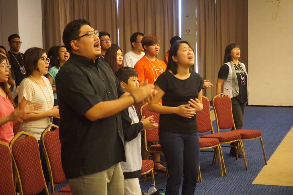 Pastor Damien Chua and his wife Mei Ying worshipping God