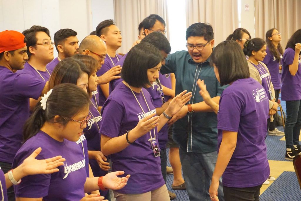 Pastor Damien Chua praying for the participants of Exponential camp in Taiping Golf Resort