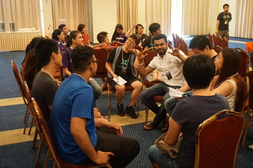 The young adults sitting in their groups for morning devotion