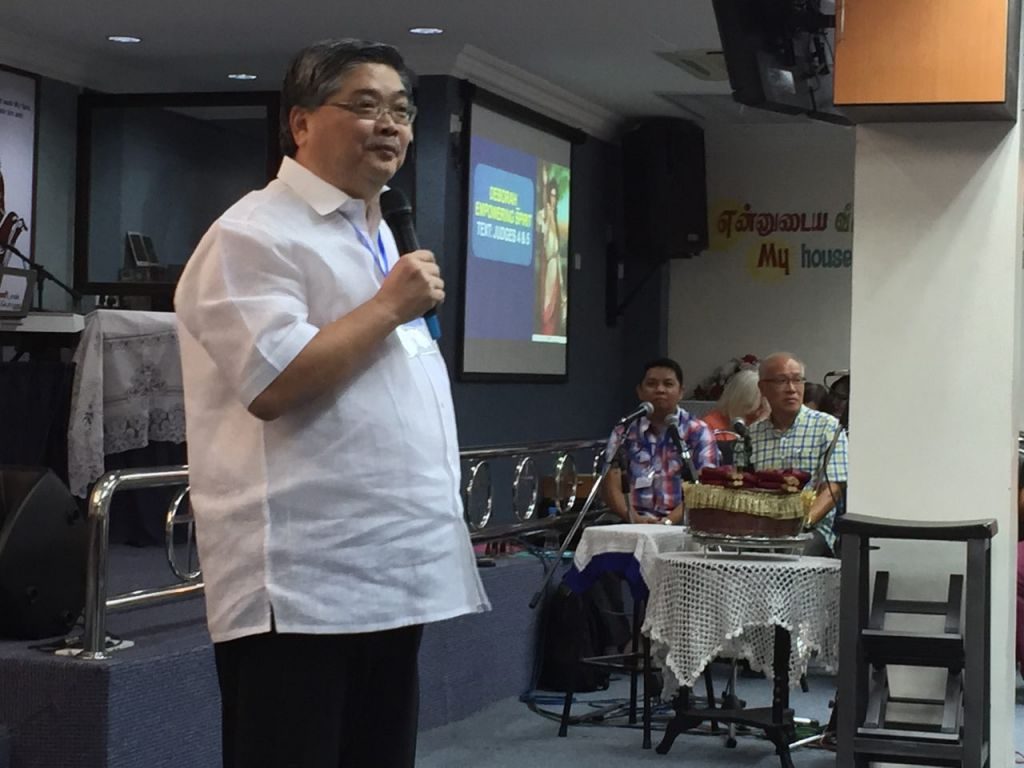 Pastor Alan Tan preaching onstage in PAAG