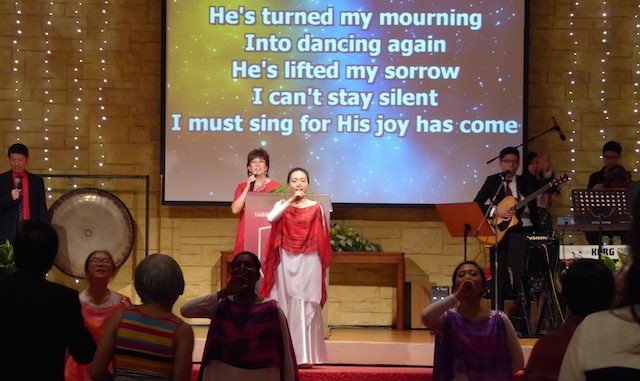 Pastor Irene Chong worshipping God onstage