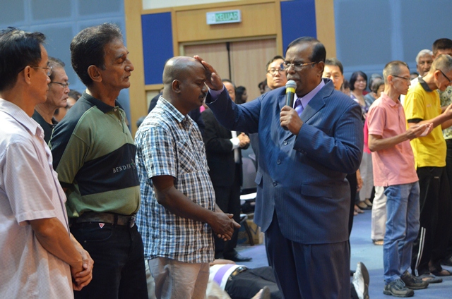 Dr Ananda Sitra praying for the attendees at his last visit in Glad Tidings Petaling Jaya