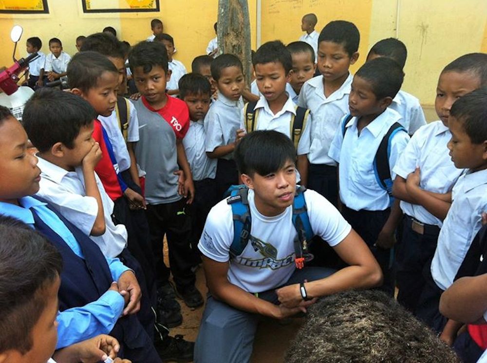 Volunteer Jansen Yeoh being surrounded by the Temiars children in Kuala Betis